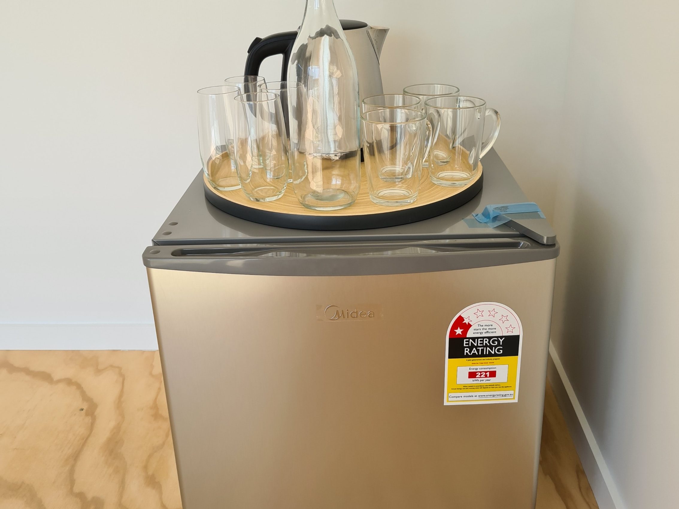 fridge with glasses and kettle on top