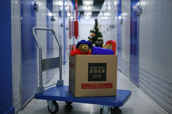 Storage units with a trolley outside with a box with a bear and a tree
