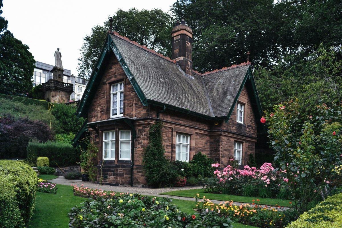 House made out of bricks with flowers in front