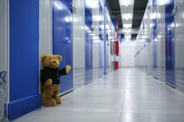 Teddy bear waving outside self storage unit